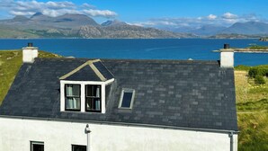 A house with a sloped roof, a small window, and a chimney. - 2 bedroom accommodation in Fearnbeg, near Applecross (Fearnbeg, near Applecross)
