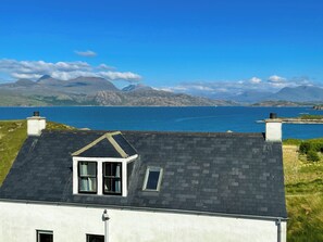 A house with a sloped roof, a small window, and a chimney. - 2 bedroom accommodation in Fearnbeg, near Applecross (Fearnbeg, near Applecross)