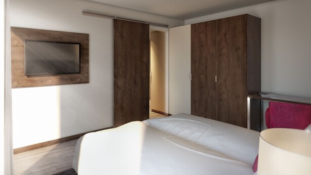 A modern hotel room with a bed, a TV mounted on the wall, and a wardrobe with sliding doors. - Heidelberg Hospitality Boarding House (Heidelberg)