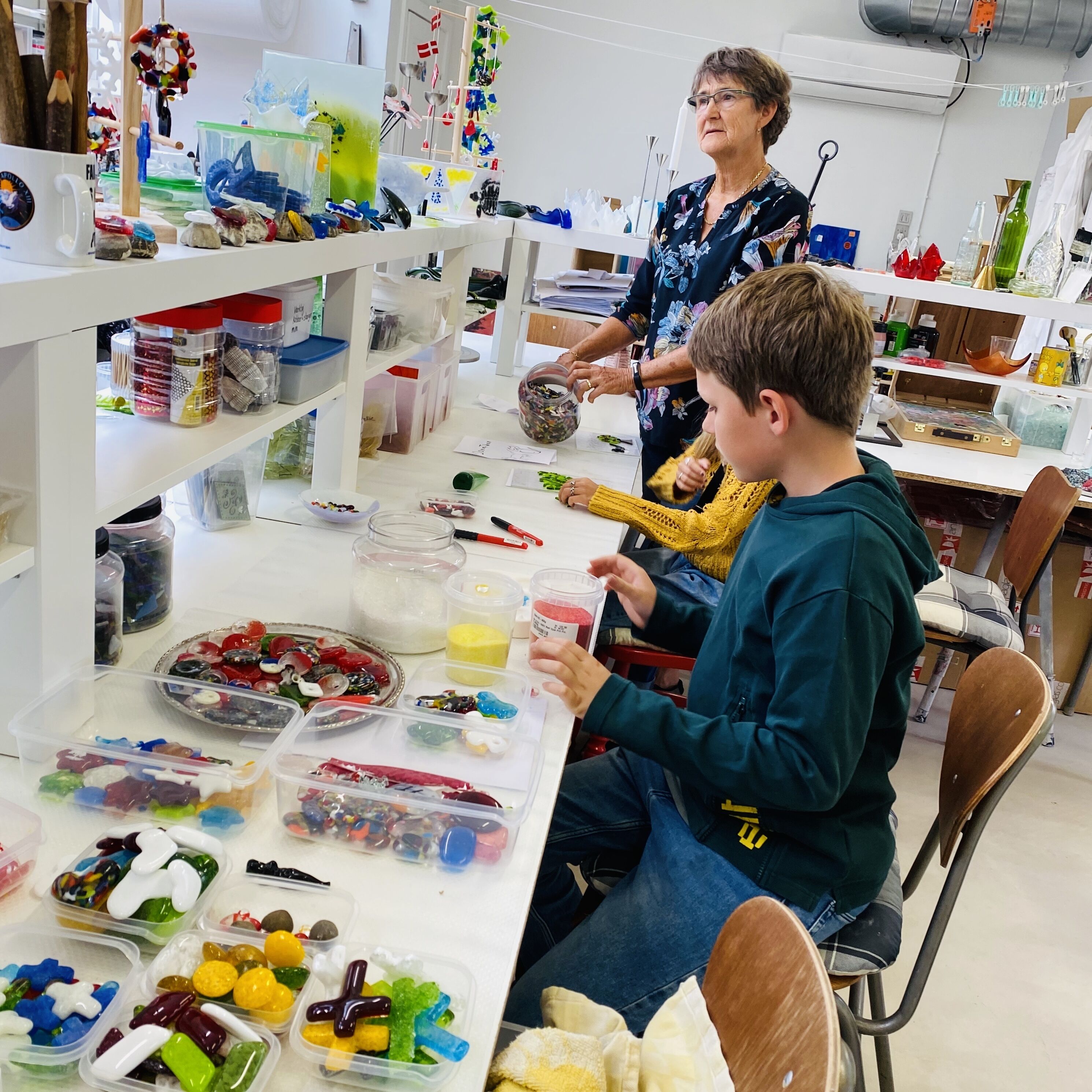 A workshop with various crafting materials and tools on shelves and tables.