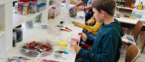 A workshop with various crafting materials and tools on shelves and tables.