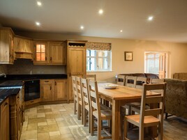 A kitchen with wooden cabinets, a dining table, and chairs.