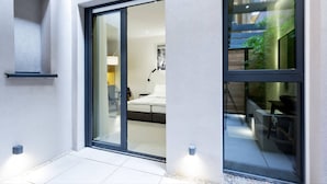 A modern hotel room with a sliding glass door leading to a balcony. - Teanna Lux Apartments (Belgrade)