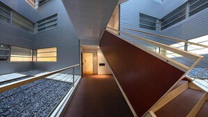 A modern interior with a central staircase, railings, and a patterned floor. - Pedrera Suites - Habitat Apartments (Barcelona)