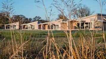Een modern wooncomplex met meerdere huizen, grote ramen en open ruimtes.