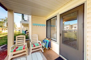 Relax on the covered porch with comfortable seating and a convenient spot to hang your beach towels.