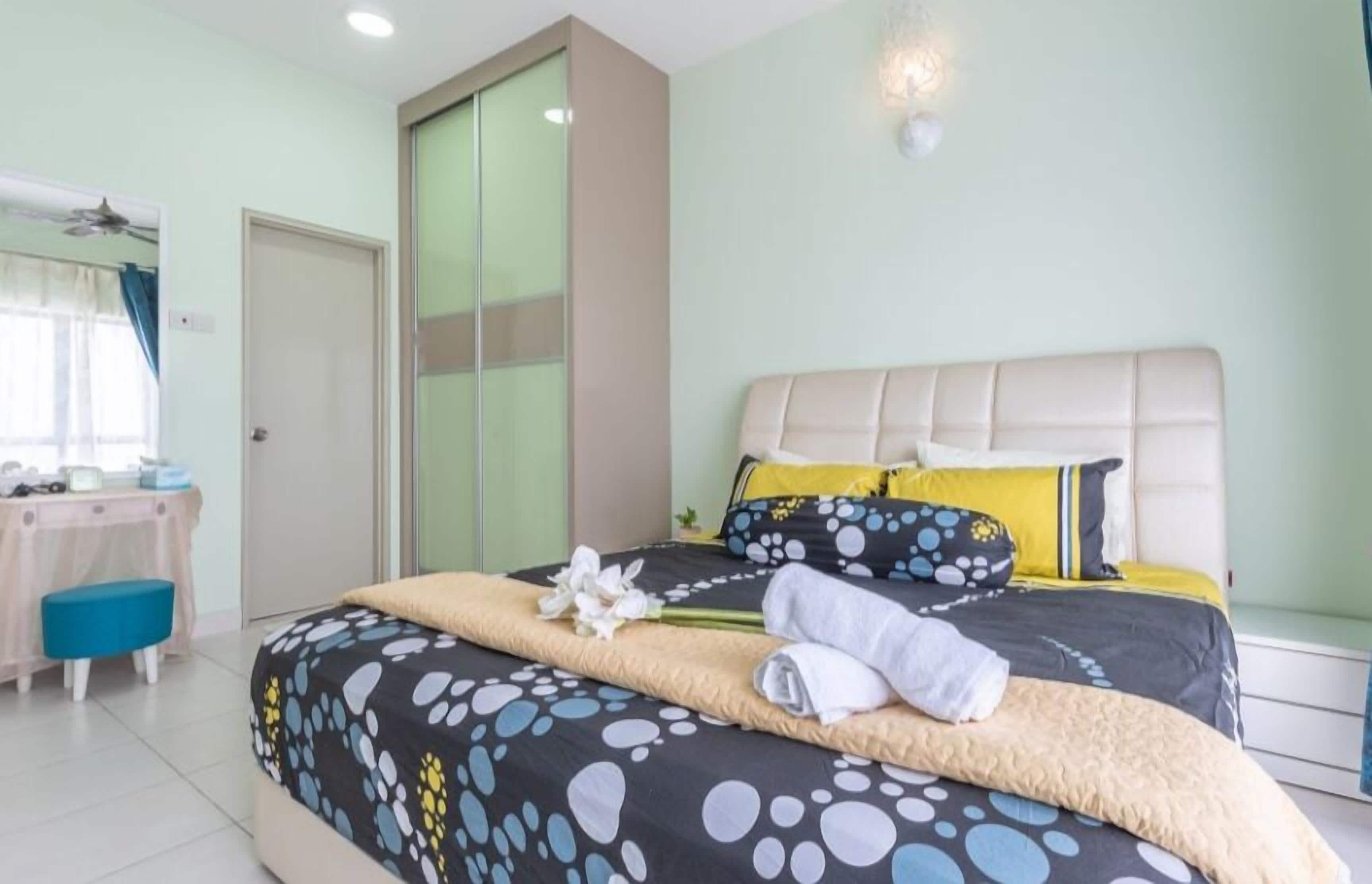 A bedroom with a bed, a desk, and a wardrobe.