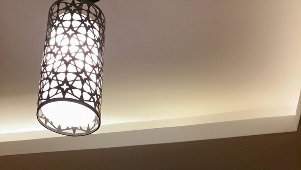 A ceiling with a geometric light fixture and a recessed ceiling light. - Superior Luxury Furnished Apartment (Cairo)
