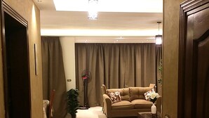 A well-lit living room with a sofa, a coffee table, and a potted plant. - Superior Luxury Furnished Apartment (Cairo)