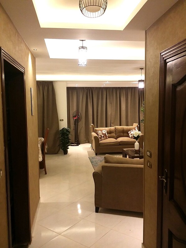 A well-lit living room with a sofa, a coffee table, and a potted plant.