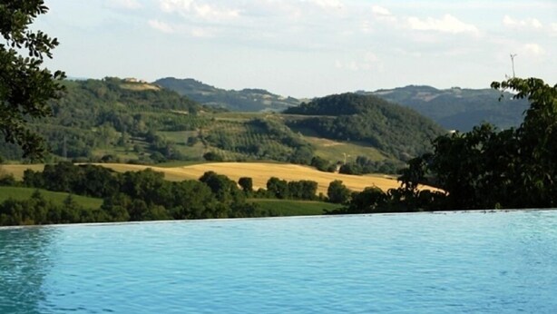 A pool with a view of a hilly landscape. - Agriturismo La Macinara (Perugia)