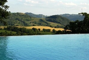 A pool with a view of a hilly landscape. - Agriturismo La Macinara (Perugia)