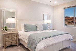 A bedroom with a bed, bedside tables, and a large window. - Oversized Private Hot Tub with XBOX (Washington)
