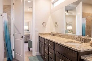 A bathroom with a large mirror, dark cabinets, and a granite countertop sink. - Oversized Private Hot Tub with XBOX (Washington)