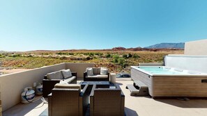 Terraza en la azotea con mobiliario exterior, una bañera de hidromasaje y tanques de propano.