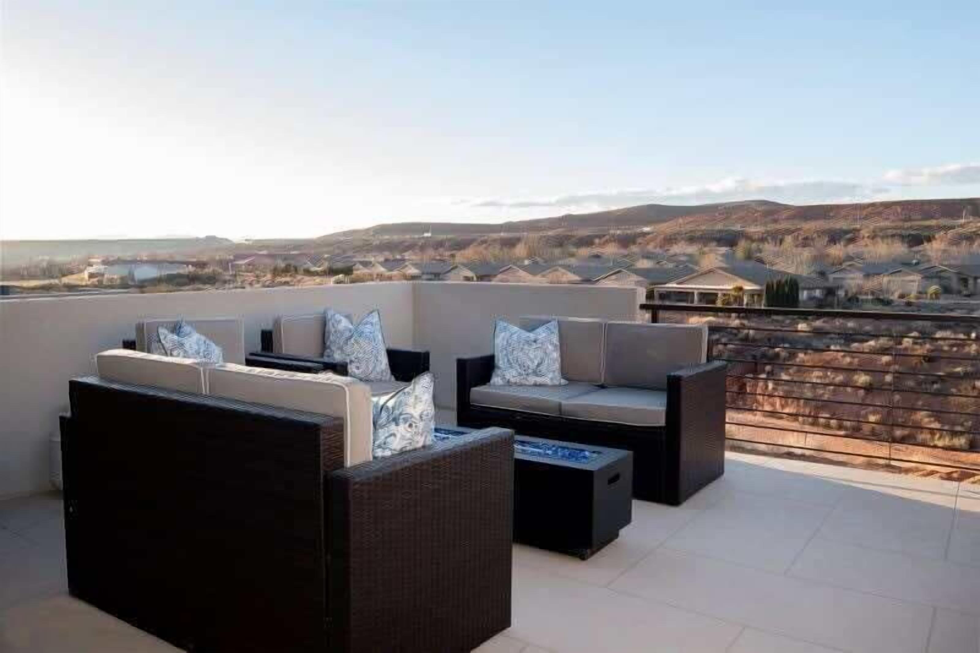 An outdoor seating area with a view of a cityscape.