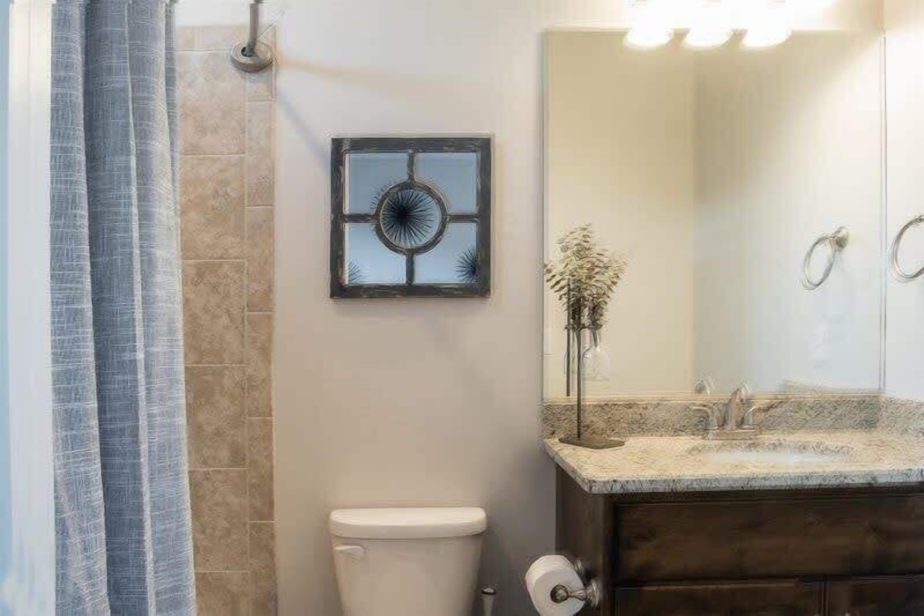 Un bagno con servizi igienici, lavandino e specchio.