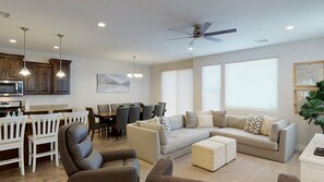 A modern living room with a sofa set, a dining area with chairs, and a kitchen with cabinets and a microwave. - Oversized Private Hot Tub with XBOX (Washington)