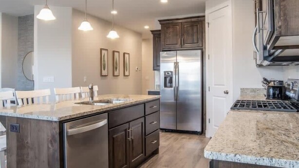 A modern kitchen with a stainless steel refrigerator, granite countertops, and wooden cabinets. - Oversized Private Hot Tub with XBOX (Washington)