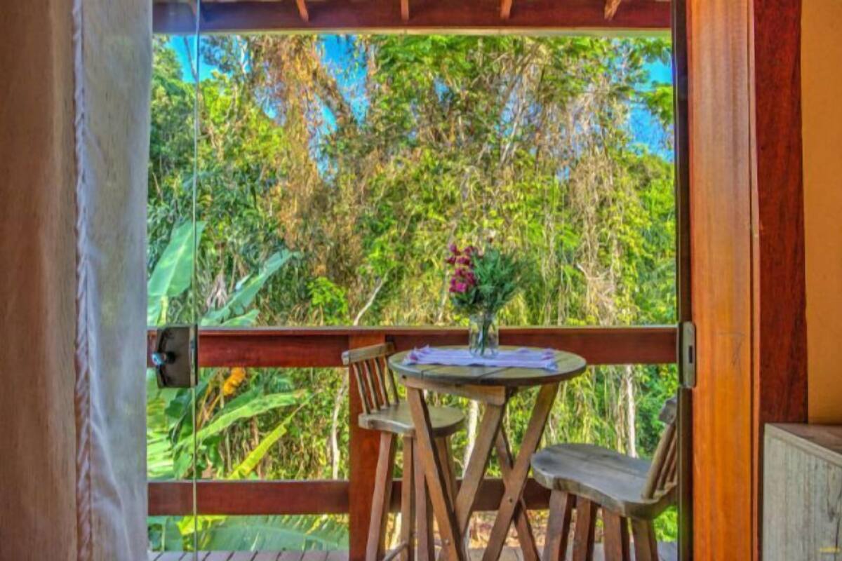 Eine Holzterrasse mit Tisch und Stühlen mit Blick auf einen üppigen Garten.