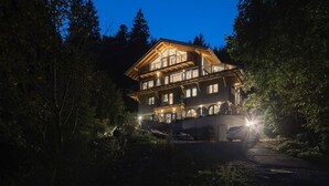 A large, multi-story wooden house with a prominent balcony, surrounded by dense forest. - Schweizerhaus Alpirsbach (Alpirsbach)