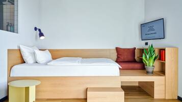 Studio | Ylelliset vuodevaatteet, tallelokero huoneessa, työpöytä