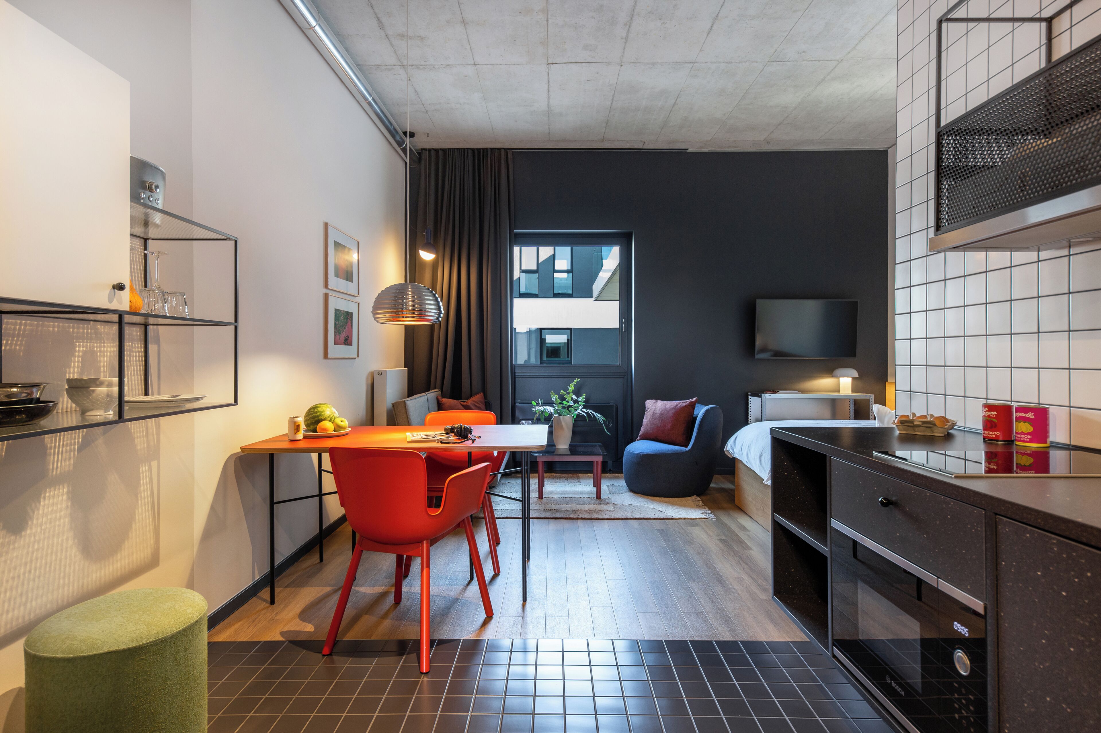 Un espace de vie compact comprenant une cuisine, un coin repas et un coin salon.