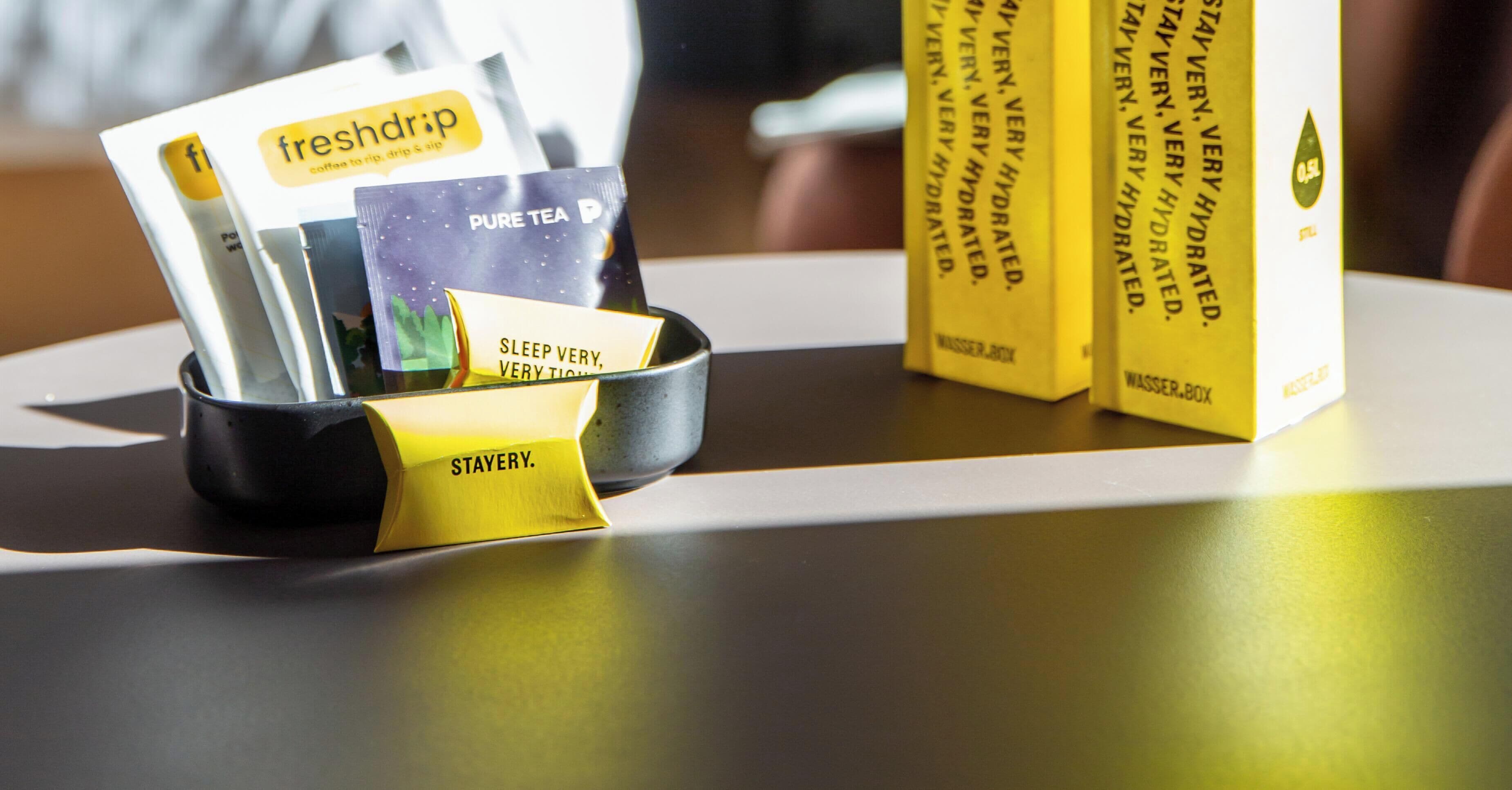 A coffee station with branded coffee packets and a branded mug.