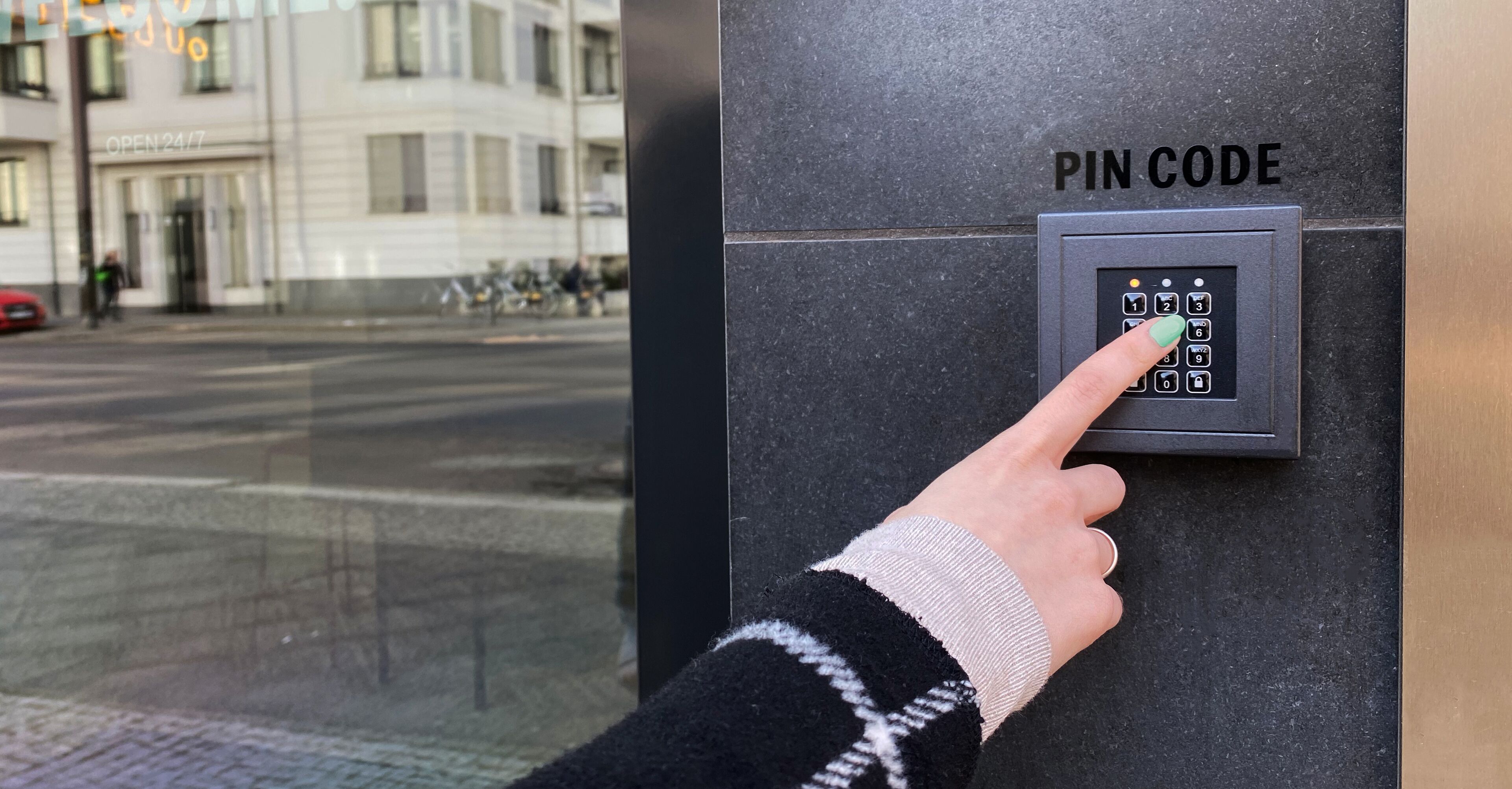 A hand entering a PIN code on a security keypad.