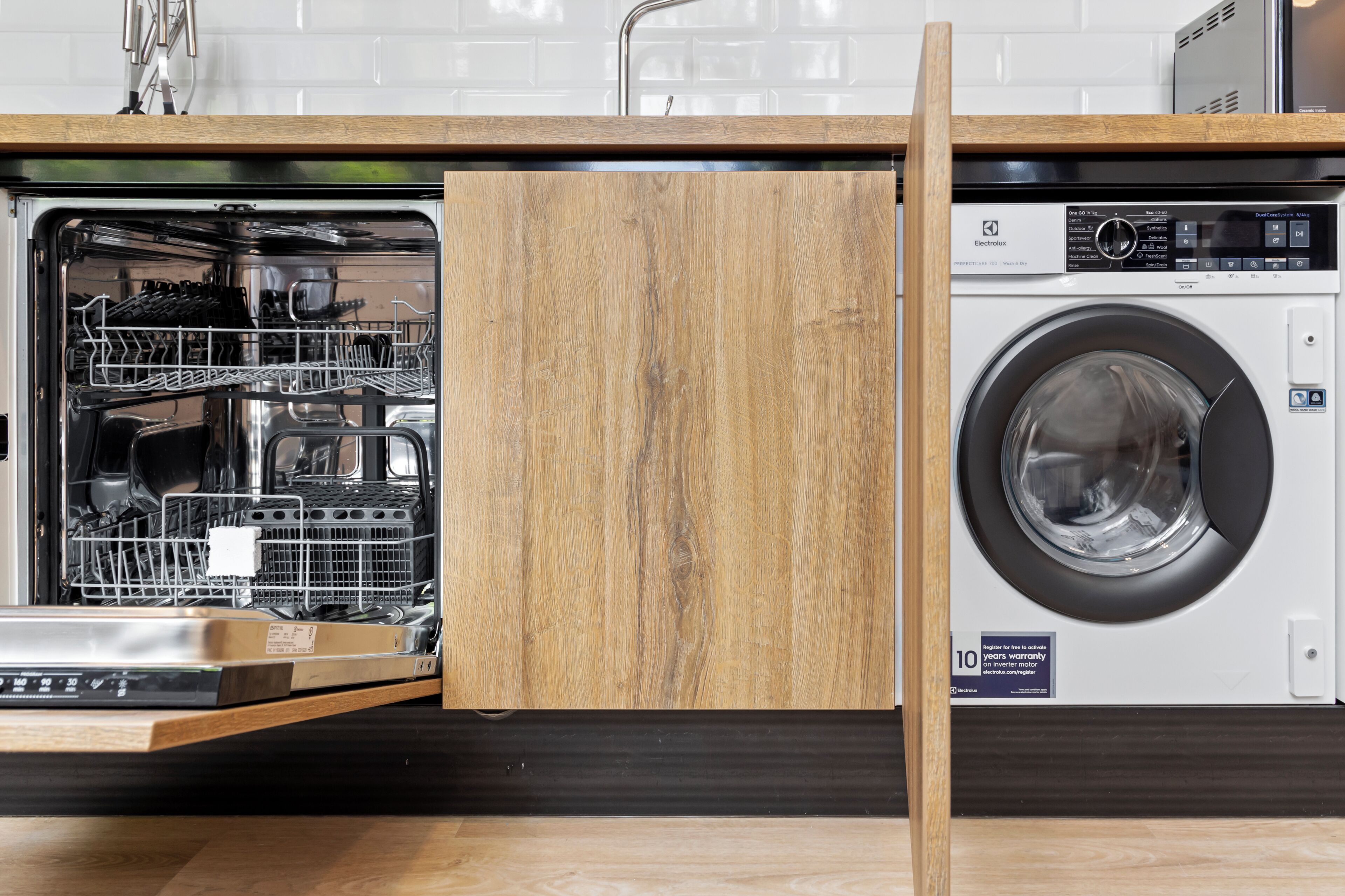 A modern kitchen with a dishwasher and a front-loading washing machine.