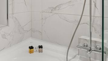 A modern bathroom with a shower, a bathtub, and marble tiles.