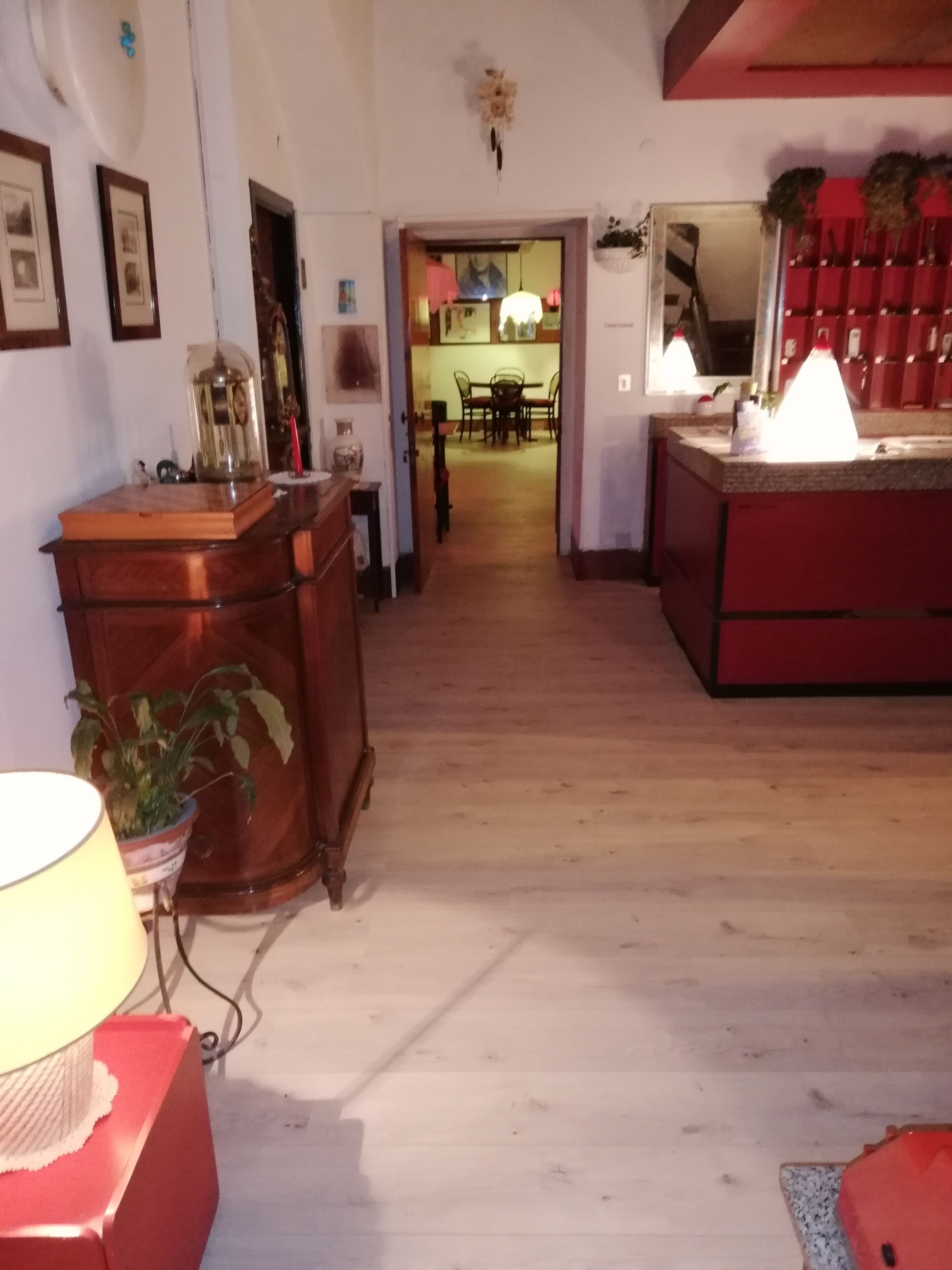 Un estrecho pasillo con suelo de madera que conduce a un comedor con una mesa y sillas.