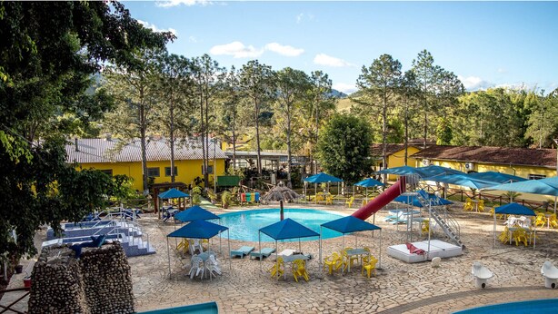 Un complejo turístico con varias piscinas, tumbonas y sombrillas.