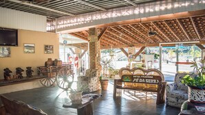 Un interior rústico con un banco de madera, decoración campestre y un letrero que dice "HOTEL FAZENDA PE DA SERRA".