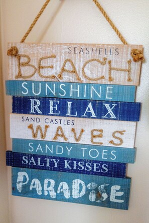 A decorative sign with phrases like 'BEACH,' 'SUNSHINE,' and 'RELAX' suggesting a beach-themed setting. - Aarondale Guest House (Hartlepool)