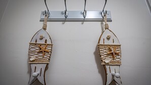 Dos adornos de temática náutica colgados en una pared blanca, cada uno con un diseño de cuerda y estrella de mar.