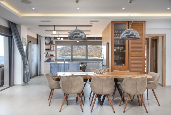 Un comedor moderno con una mesa de madera, seis sillas e iluminación colgante.