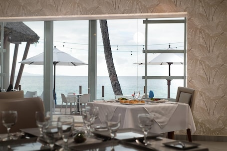 A restaurant with a view of the sea, large windows, and outdoor seating.. Select Sosua Adults Only, Trademark by Wyndham All Inclusive