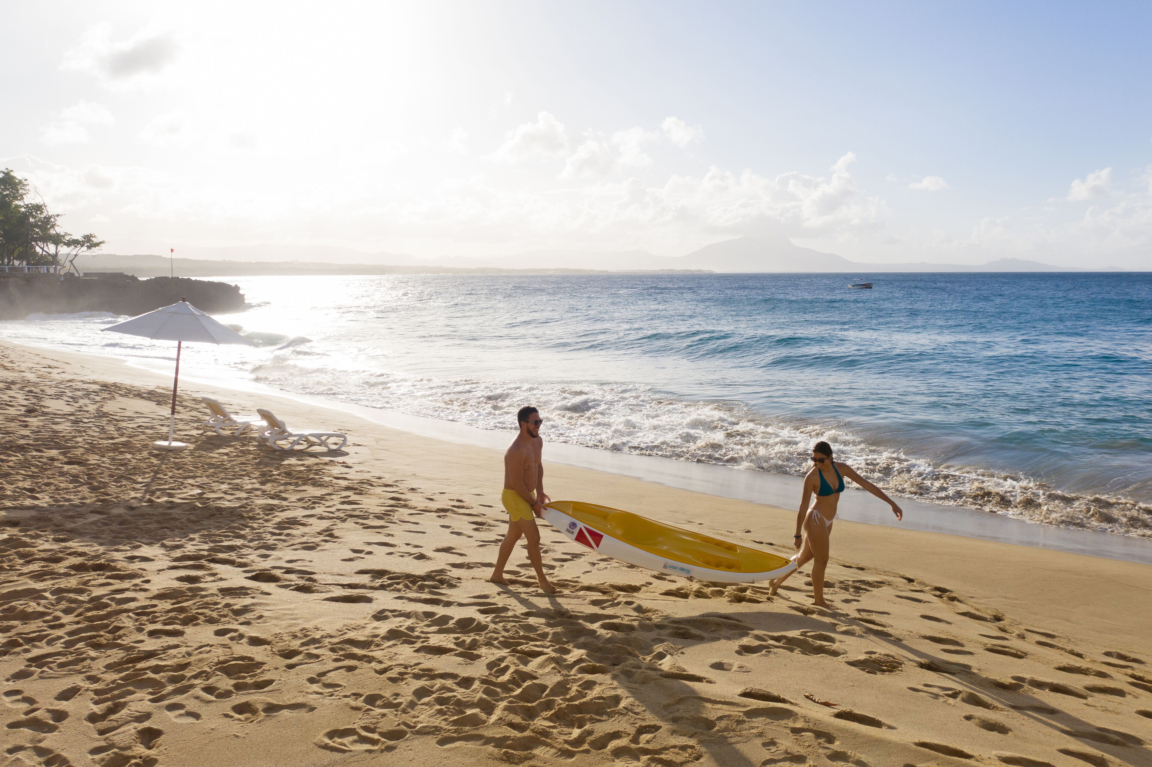 A beach with footprints, a lifeguard stand, and a clear view of the ocean.