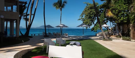 A resort with a pool area, outdoor seating, and a view of the ocean.