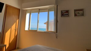 A room with a large window, a door, and two framed pictures on the wall. - Hotel Ristorante Il Triangolo (Augusta)