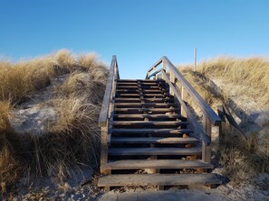 A wooden staircase leading up a sandy slope, surrounded by dry grass. - Apartment with Baltic Sea view, 300 m near the beach (Heiligenhafen)