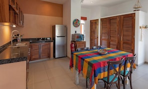 Una cocina con refrigerador, estufa y armarios de madera.