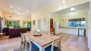 Una sala de estar acogedora con un sofá, una mesa de comedor con sillas y un televisor.