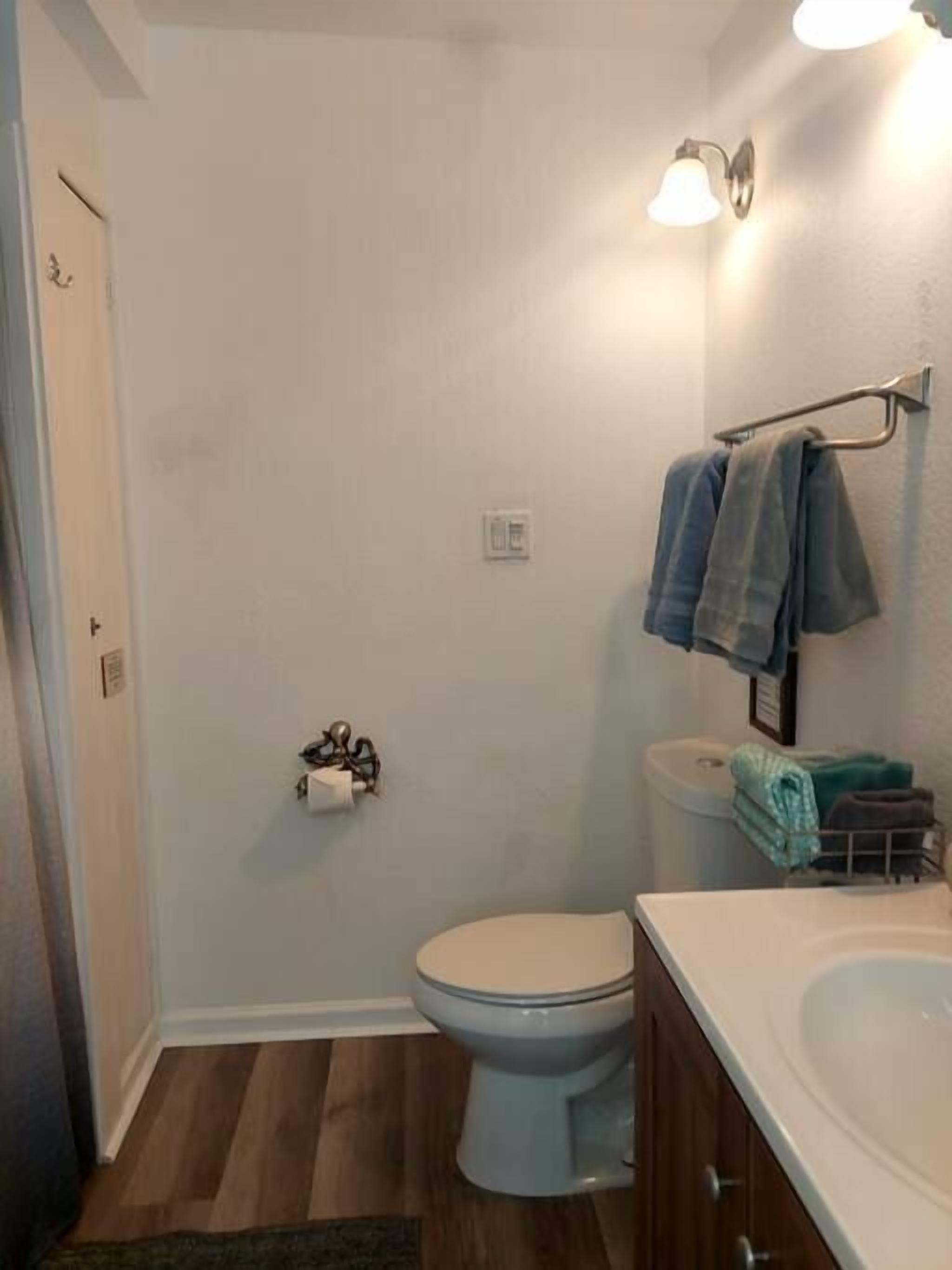 Ein Badezimmer mit Toilette, Waschbecken und Handtuchhalter.