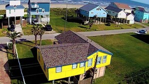 A coastal residential area with houses, a clear sky, and the ocean in the background. - Ocean Views & Steps to Car-Free Beach (Galveston)