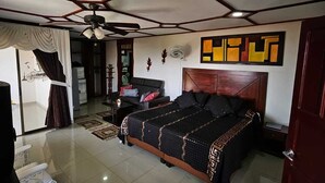 A bedroom with a large bed, a ceiling fan, and a wall-mounted artwork. - Tucurinca Hotel & Spa (Montenegro)