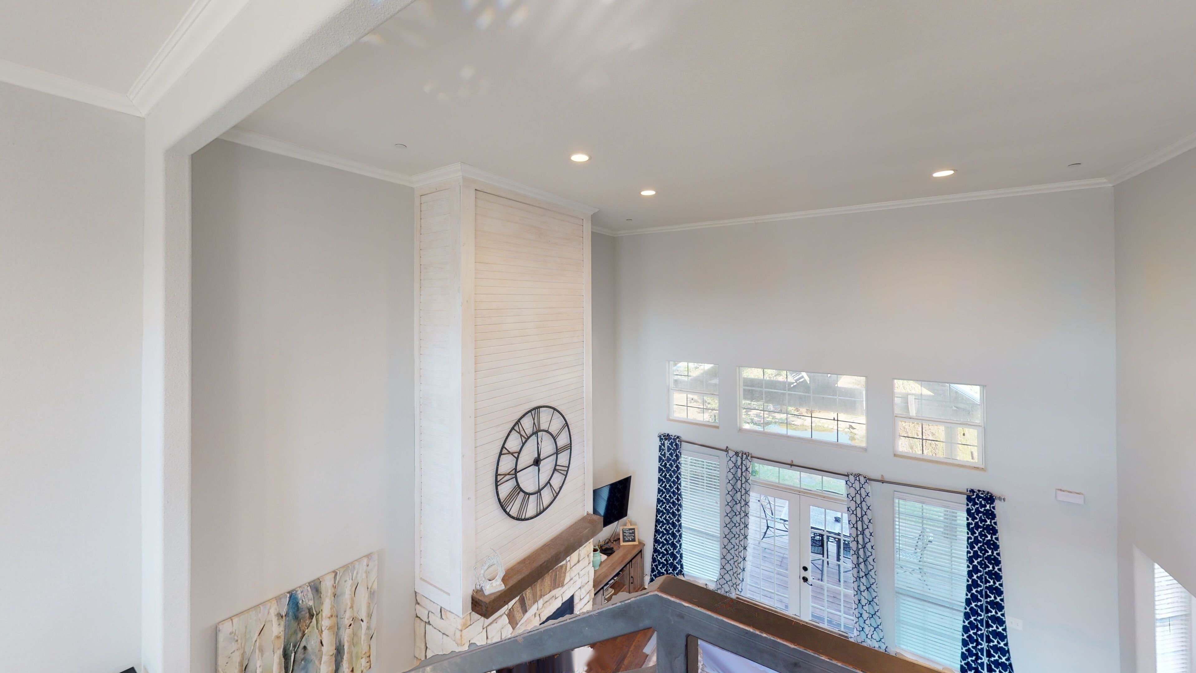Un interior espacioso con techo alto, un reloj decorativo y varios ventanales que dejan entrar luz natural.