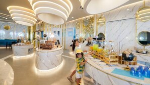 A modern hotel lobby with marble flooring, a reception desk, and a bar area with a globe and blue glasses. - Wyndham La Vita Rawai Phuket (Rawai)