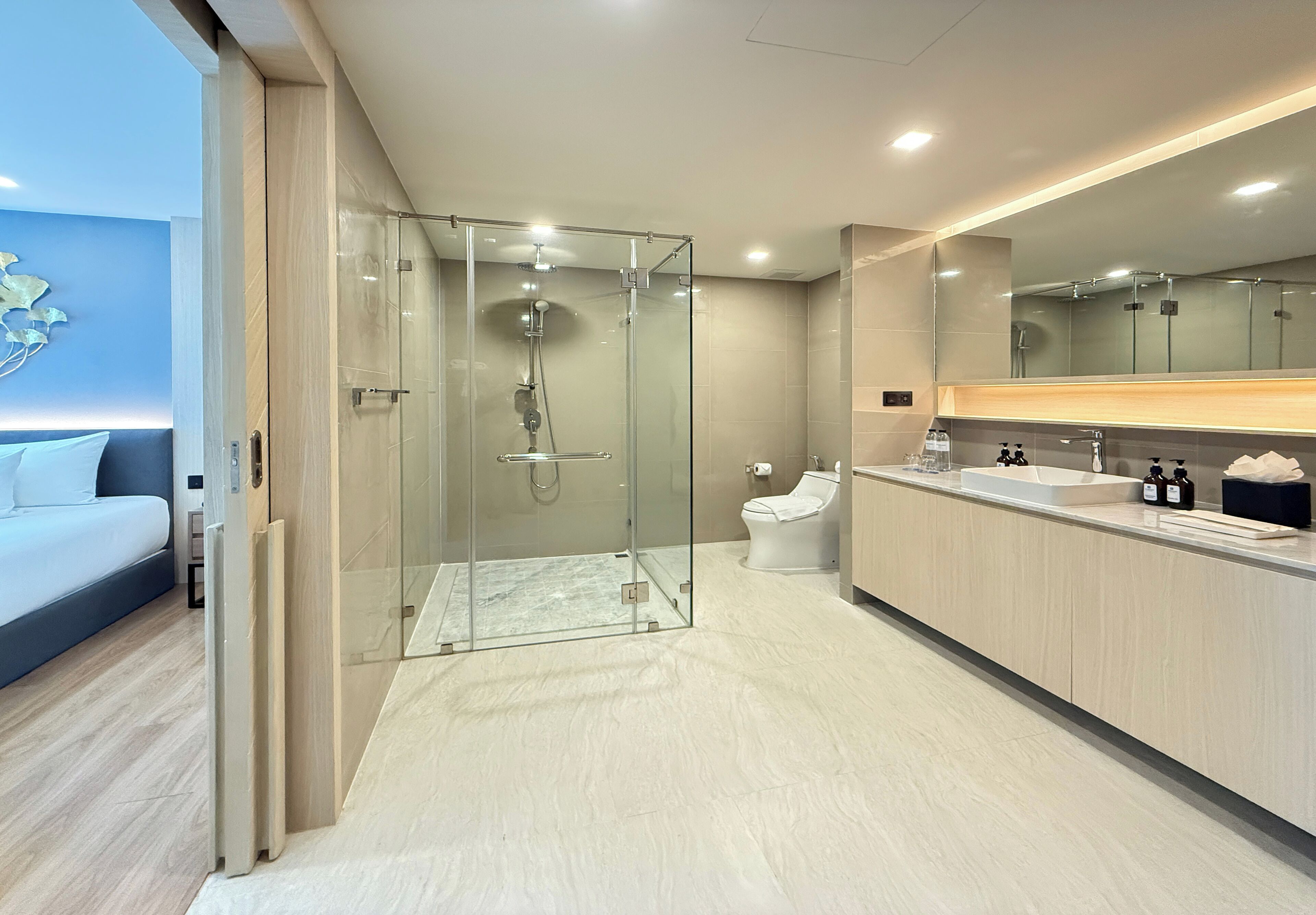 Un bagno moderno con doccia vetrata, un water e un lavabo con specchio sopra.